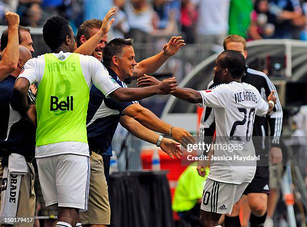Dane Richards of the Vancouver Whitecaps celebrates his second half goal with teammates on the side line during their game against Real Salt Lake at...