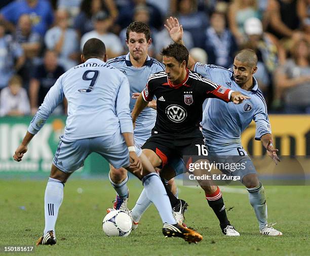 Josh Wolff of the D.C. United tries to clear the ball away from Teal Bunbury, Paulo Nagamura and Michael Thomas of the Sporting Kansas City in the...