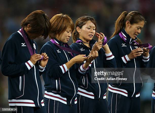 Kozue Ando, Aya Miyama, Nahomi Kawasumi and Homare Sawa watch the Silver medals on the podium after the Women's Football gold medal match between the...