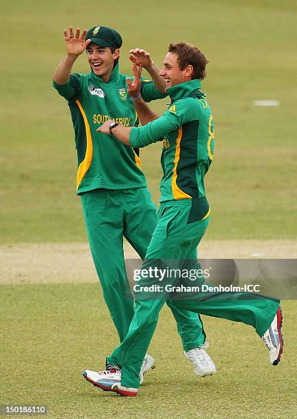 Theunis de Bruyn of South Africa celebrates with team mate Chad Bowes after taking the wicket of Naeem Islam jr of Bangladesh during the ICC U19...