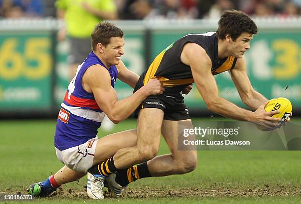 Clay Smith of the Bulldogs tackles Trent Cotchin of the Tigers during the round 20 AFL match between the Richmond Tigers and the Western Bulldogs at...