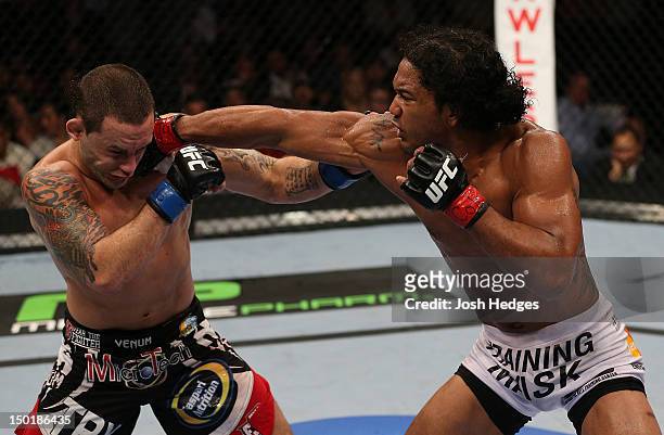 Benson Henderson punches Frankie Edgar during their lightweight championship bout at UFC 150 inside Pepsi Center on August 11, 2012 in Denver,...