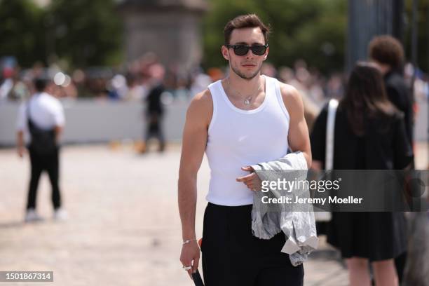 Fashion Week guest is seen wearing a white tanktop and black suit pants outside Dior Homme during the Menswear Spring/Summer 2024 as part of Paris...