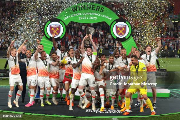 Declan Rice of West Ham United lifts the Winners' trophy as he celebrates with team mates on the podium following the UEFA Europa Conference League...