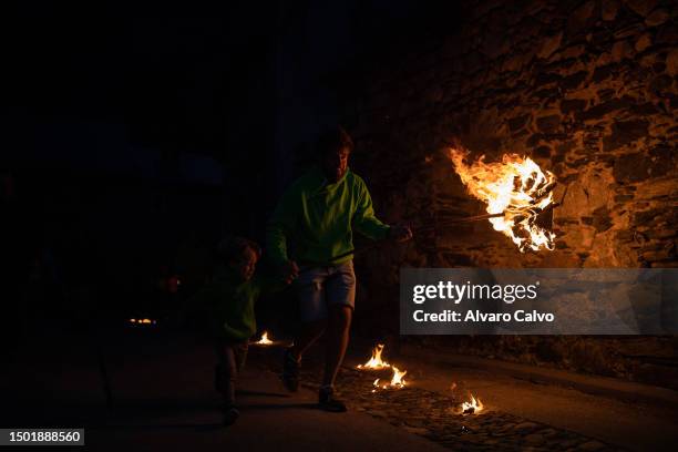 Father and son prepare to walk the streets with a falla for the solstice celebration on June 23, 2023 in Sahun, Spain. The Fallas festival in the...
