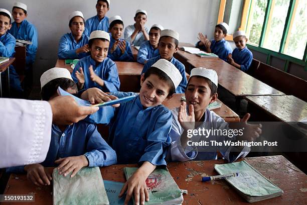Hamidullah is praised by his teacher and classmates for a good grade in a classroom of Sher Zahed orphanage in Kandahar. Hamidullah's father,...