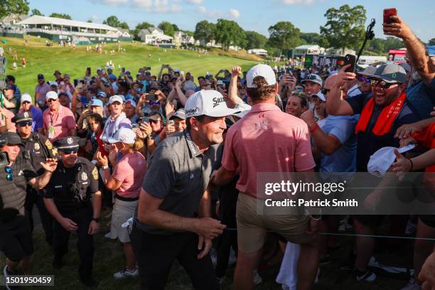 Keegan Bradley of the United States is congratulated by fans as he walks off the 18th green after winning during the final round of the Travelers...