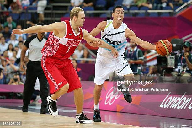 Anton Ponkrashov of Russia competes for a loose ball with Pablo Prigioni of Argentina during the Men's Basketball bronze medal game between Russia...