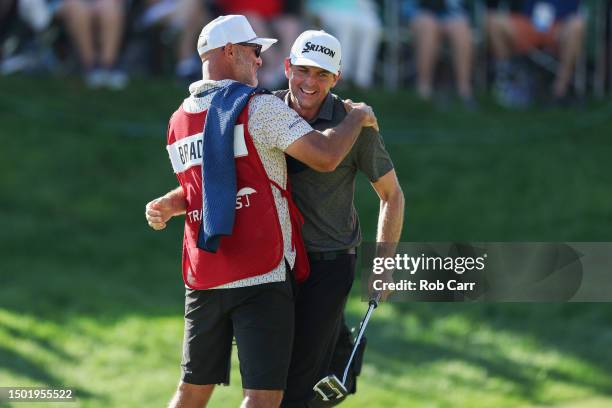 Keegan Bradley of the United States and caddie Scott Vail celebrate winning on the 18th green during the final round of the Travelers Championship at...