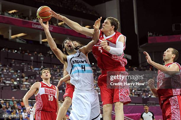 Timofey Mozgov of Russia blocks Luis Scola of Argentina during the Men's Basketball bronze medal game between Russia and Argentina on Day 16 of the...