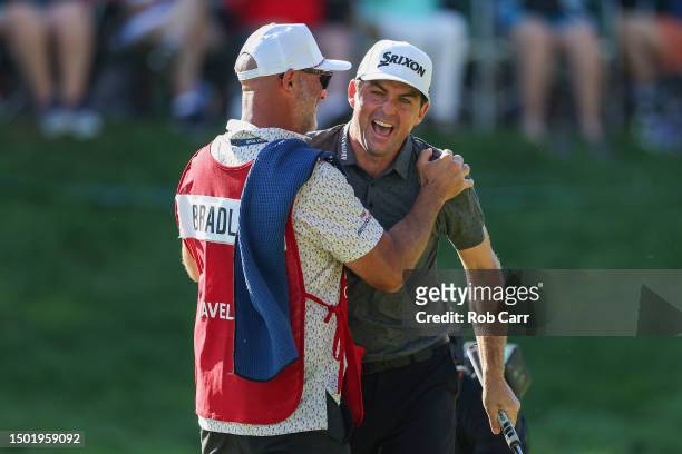 Keegan Bradley of the United States and caddie Scott Vail celebrate winning on the 18th green during the final round of the Travelers Championship at...