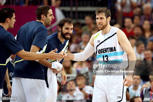 Team mates congratulate Andres Nocioni of Argentina on making a shot during the Men's Basketball bronze medal game between Russia and Argentina on...