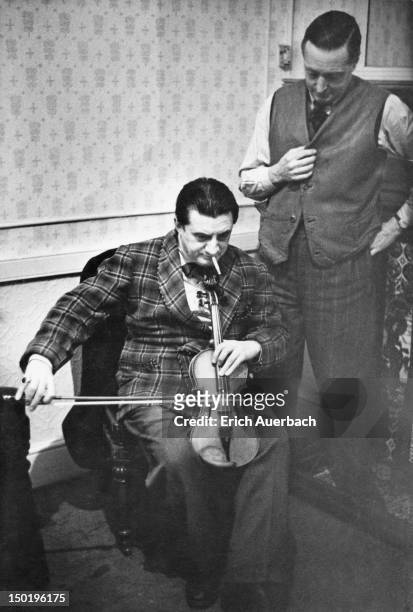 British conductor and cellist Sir John Barbirolli playing a violin as if it were a viol, circa 1949.