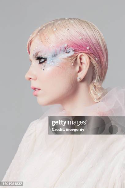 blonde girl in white blouse in studio on white background. short pink hair. model in skirt. beauty makeup with feather. style and fashion. haute couture - pink hair stock pictures, royalty-free photos & images