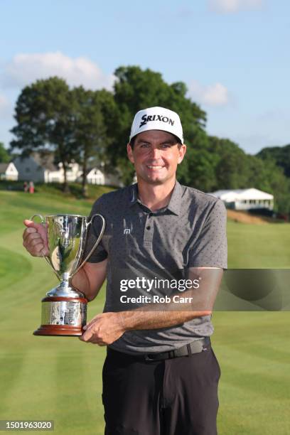 Keegan Bradley of the United States celebrates with the trophy after winning the final round of the Travelers Championship at TPC River Highlands on...