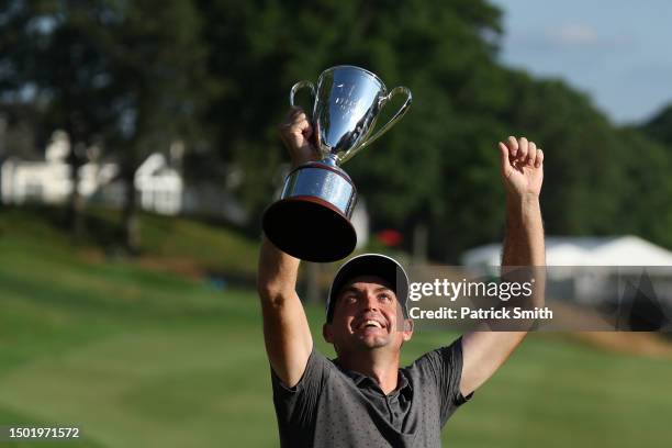 Keegan Bradley of the United States celebrates with the trophy during the trophy ceremony after winning the final round of the Travelers Championship...