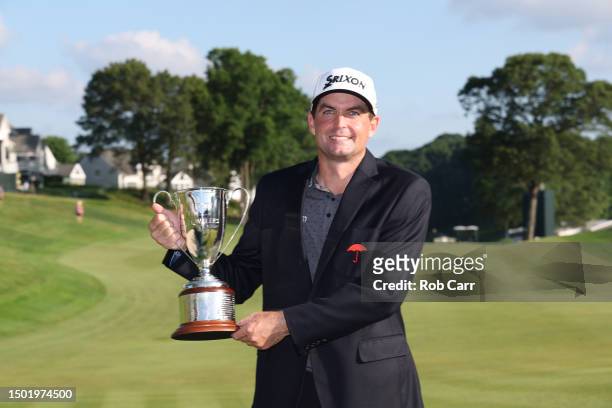 Keegan Bradley of the United States celebrates with the trophy after winning the final round of the Travelers Championship at TPC River Highlands on...