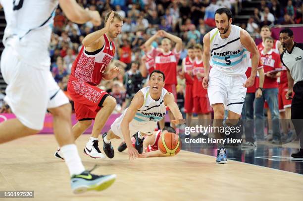 Pablo Prigioni of Argentina dives for a loose ball past Sergey Monya of Russia during the Men's Basketball bronze medal game between Russia and...