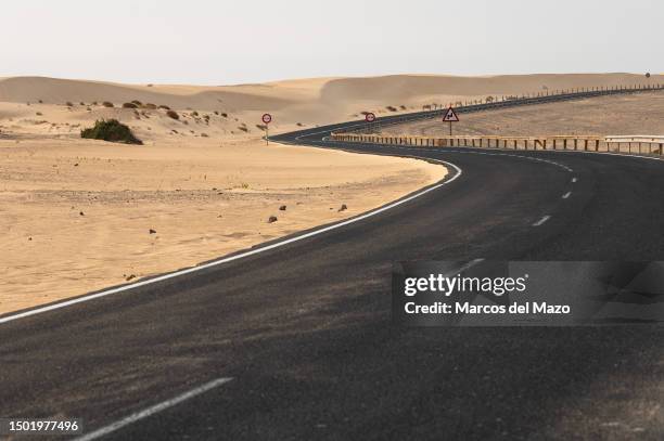 Road crossing the Dunes of Corralejo, north of Fuerteventura in the Canary Islands. The Corralejo Dunes are a set of dunes that are part of the...