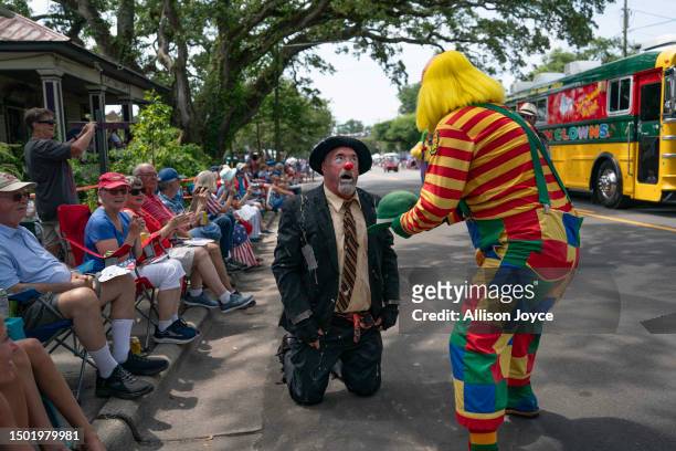 Clown fans another clown from the heat while they participate in the annual Independence Day Parade on July 4, 2023 in Southport, North Carolina. The...