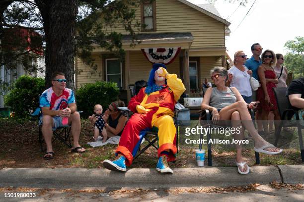 Clown rests in the heat with some cold water while he participates in the annual Independence Day Parade on July 4, 2023 in Southport, North...