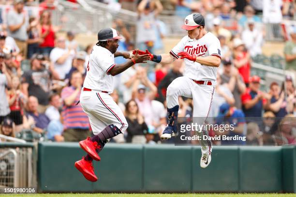 Max Kepler of the Minnesota Twins celebrates his three-run home run with third base coach Tommy Watkins as he rounds the bases against the Kansas...