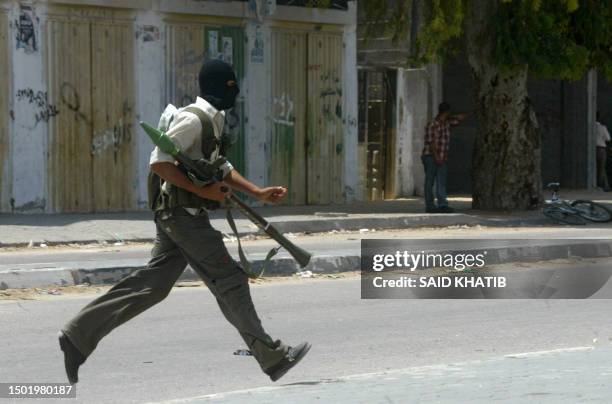 Palestinian militant carrying a rocket propelled grenade , rushes during factional fighting at Rafah refugee camp, in the southern Gaza Strip, 17 May...