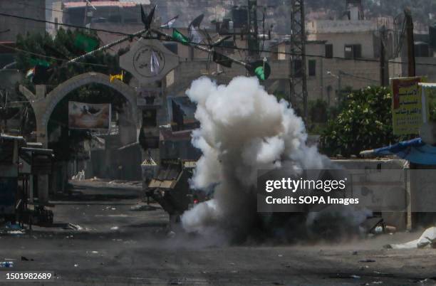 Thick smoke billows around an Israeli military vehicle after a homemade explosive device thrown by a Palestinian youth exploded near it in the Jenin...