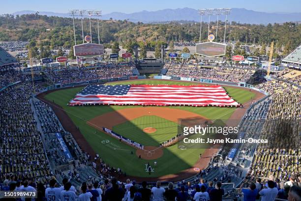 An American flag is held by members of the U.S. Military during the national anthem prior to the game between the Los Angeles Dodgers and the...