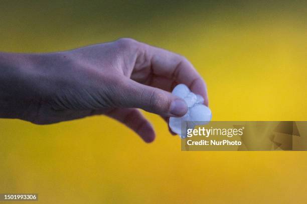 Woman keeping hail stones on hand is seen after a huge hailstorm in L'Aquila, Italy, on July 4, 2023.