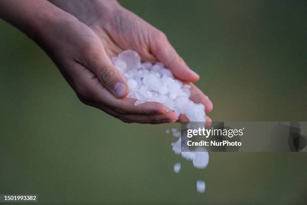 Woman keeping hail stones on hands is seen in L'Aquila, Italy, on July 4, 2023.