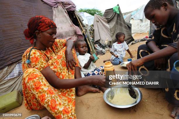 Family of four share porridge for breakfast at an IDP camp 17km from Mogadishu on May18, 2009. Families at different IDP camps are experiencing...