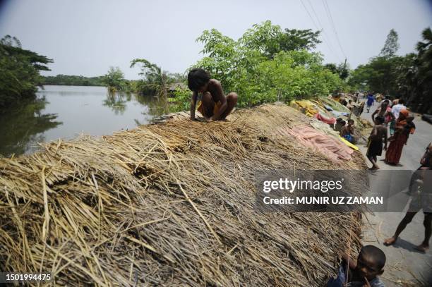 Displaced villagers construct make-shift shelters on the street after their homes were flooded in the Koyra area on the outskirts of Khulna, some 400...