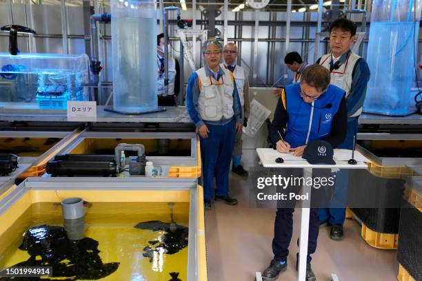 Rafael Mariano Grossi, Director General of the International Atomic Energy Agency, right, signs on agreements to cooperate with Tokyo Electric Power...