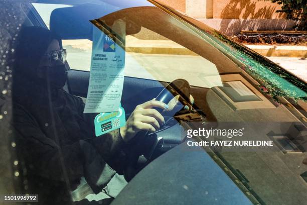 Woman drives a vehicle along a street in Riyadh on July 5, 2023. Saudi Arabia started allowing women to drive five years ago on June 24 ending the...