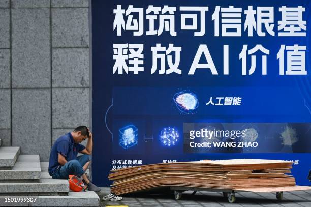 Worker rests outside the venue hosting the World Artificial Intelligence Conference in Shanghai on July 5, 2023.