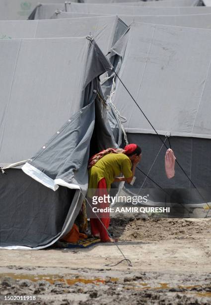 Pakistaniwoman displaced by floods washes her face outside her tent at a camp in Sukkur on August 14, 2010. Pakistan's Prime Minister Yousuf Raza...