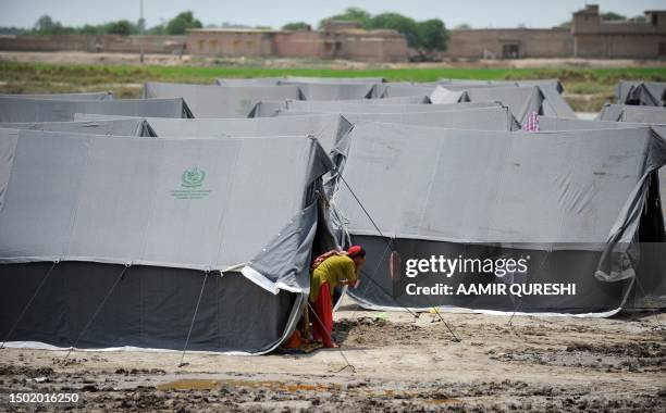 Pakistaniwoman displaced by floods washes her face outside her tent at a camp in Sukkur on August 14, 2010. Pakistan's Prime Minister Yousuf Raza...