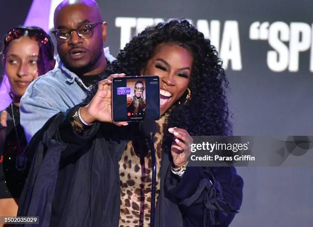 Teyana "Spike Tey" Taylor is seen on a smartphone screen held by her mom performs onstage during the BET Awards 2023 at Microsoft Theater on June 25,...
