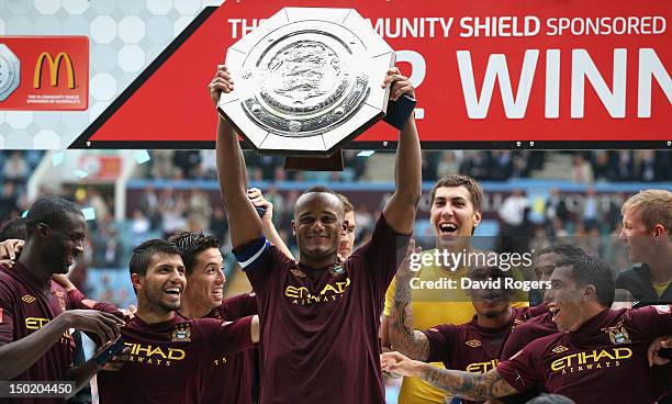 Vincent Kompany the Manchester City captain raises the trophy after their victory during the FA Community Shield match between Manchester City and...