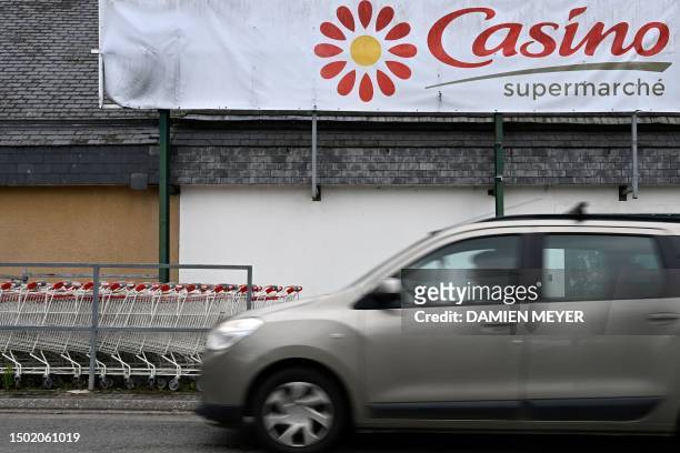 Car rides past the logo of Casino at the entrance of a Casino shop in Ploubalay, western France on July 5, 2023. Their intentions were known, but...