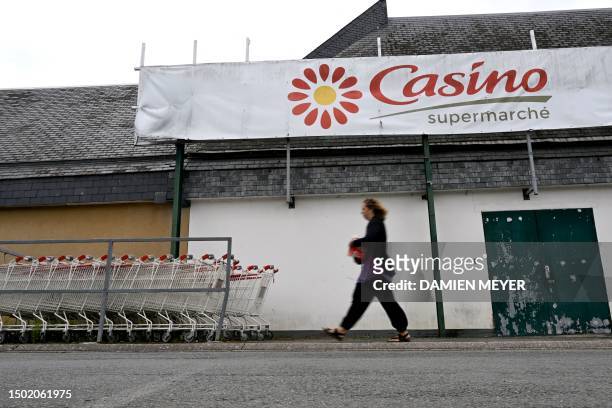 Woman walks past the logo of Casino and trolleys at the entrance of a Casino shop in Ploubalay, western France on July 5, 2023. Their intentions were...