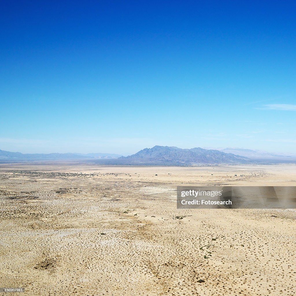 Aerial view of remote California desert with mountain range in background