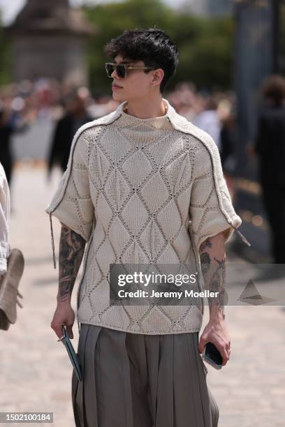 Fashion Week guest is seen wearing a beige knit shirt, beige brown plissee midi skirt and brown matching statement sneaker outside Dior Homme during...