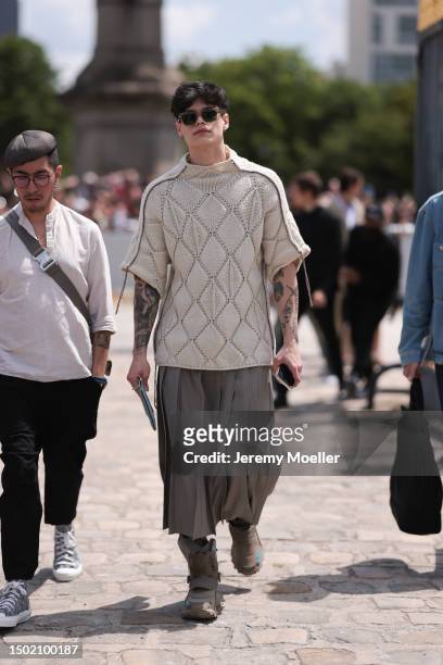 Fashion Week guest is seen wearing a beige knit shirt, beige brown plissee midi skirt and brown matching statement sneaker outside Dior Homme during...