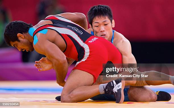 Tatsuhiro Yonemitsu of Japan, right, won the gold medal by defeating Sushil Kumar of India, left, in the gold medal match of the men's 96kg freestyle...