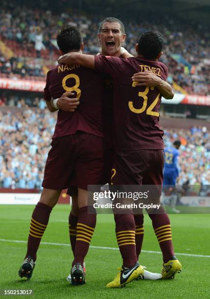 Samir Nasri of Manchester City celebrates scoring his team's third goal with team mates Aleksandar Kolarov and Carlos Tevez during the FA Community...