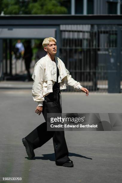 Big Matthew wears a black t-shirt, a white latte cargo nylon bomber coat, black large wide legs pants, black shiny leather ankle boots, outside...