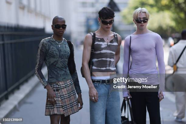 Fashion Week guest are seen wearing a Burberry checked mini skirt, black boots the other one is wearing a cropped tie dye top, white underwear, black...