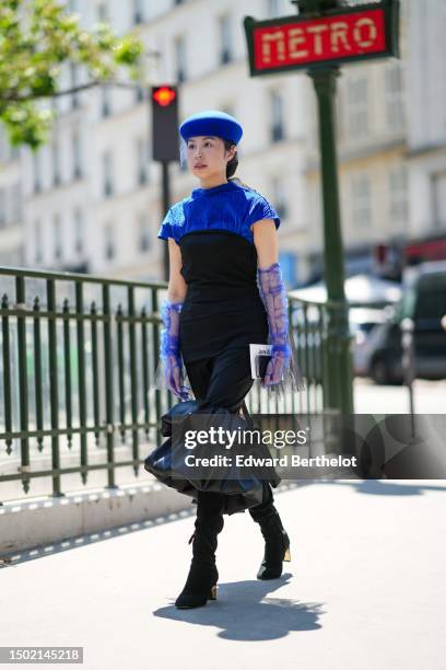 Gloria Wen wears a royal blue felt wool beret from Maison Michel with embroidered fishnet, a royal blue embossed striped pattern high neck / short...